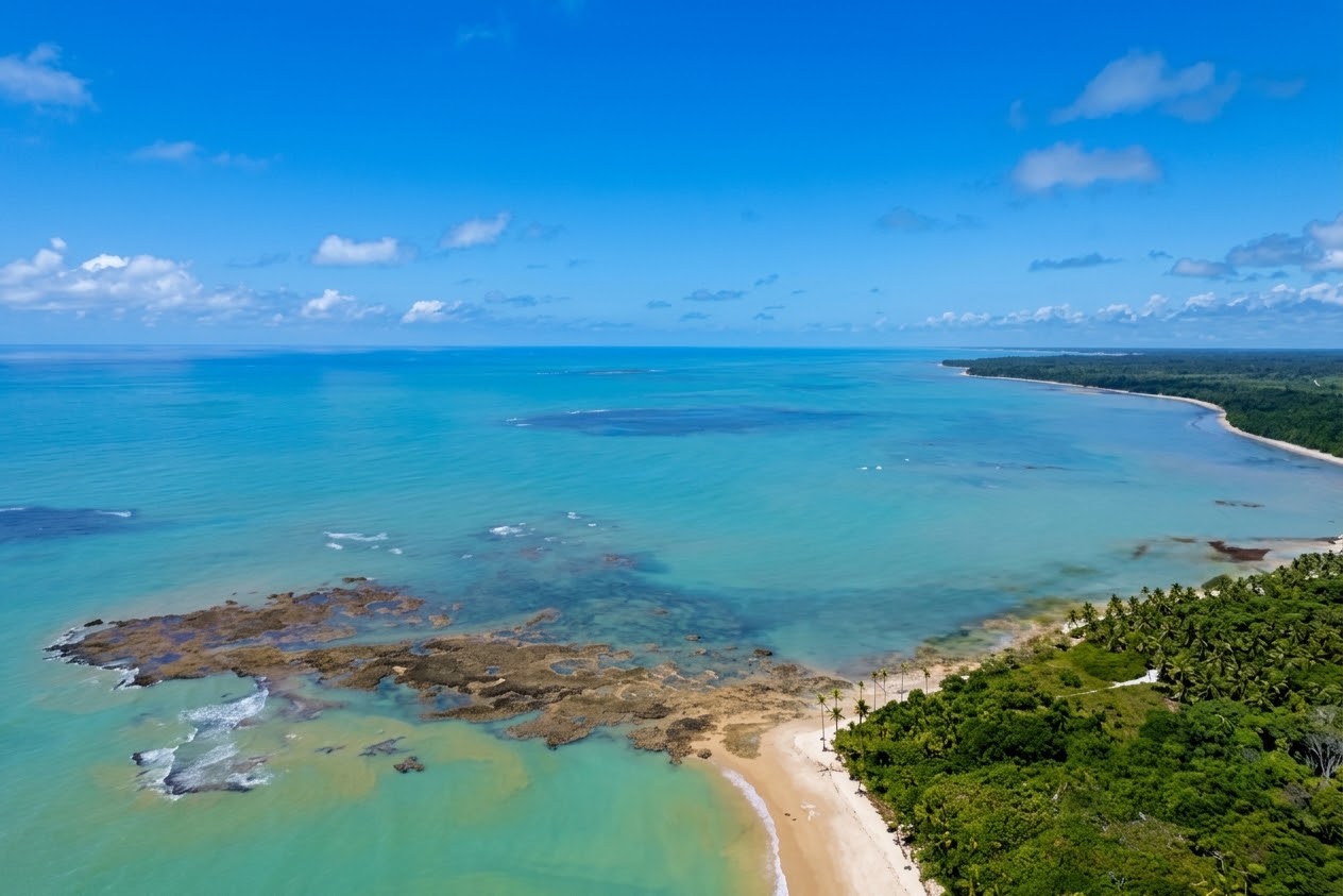 Vista aérea da praia em Trancoso, com recifes e mar turquesa